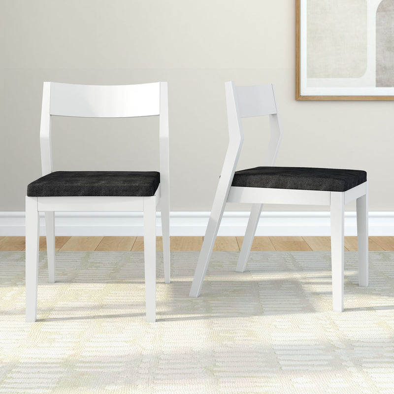 Modern white dining chairs with black cushions on a light-patterned rug in a minimalist room setting.