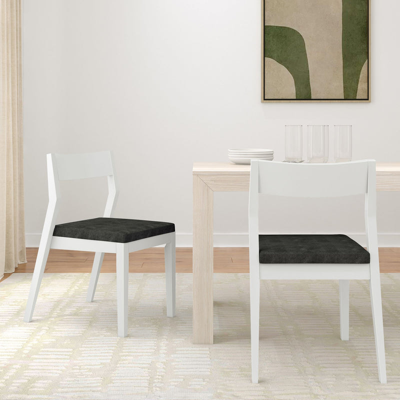 Modern minimalist dining room with white chairs and a light wood table on patterned carpet.