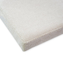 Light beige textured fabric surface, close-up of corner detail.
