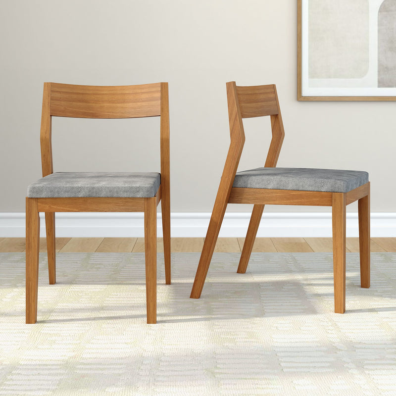 Wooden dining chairs with gray cushions on a light rug in a contemporary room.