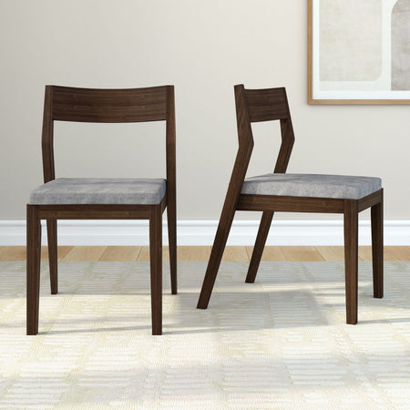 Contemporary wooden dining chairs with grey cushions on a light carpet in a modern living room.