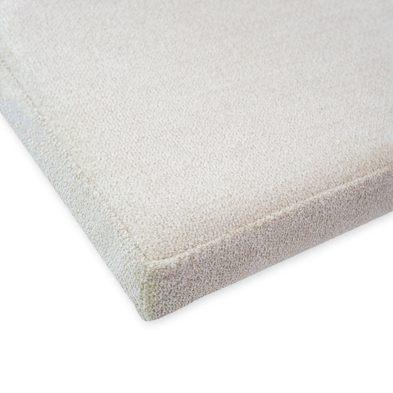 Close-up of a soft beige textured rug corner, showcasing quality material and craftsmanship.