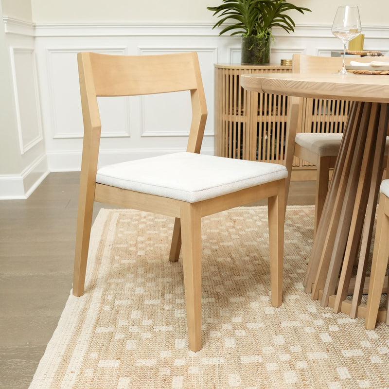 Modern wooden dining chair with white cushioned seat in a stylish dining room setting.