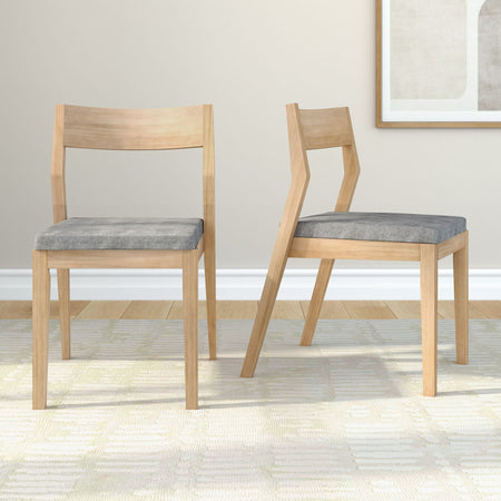 Set of 2 light wood dining chairs with gray upholstered seats and angular mid-century modern frames in a bright minimalist dining room.