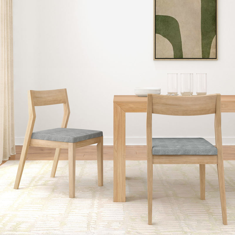 Minimalist dining room with wooden table and chairs, featuring grey cushioned seats, modern decor, and natural light.