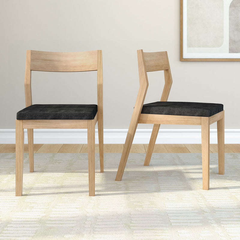 Modern wooden dining chairs with black cushioned seats in a minimalist living room setting.