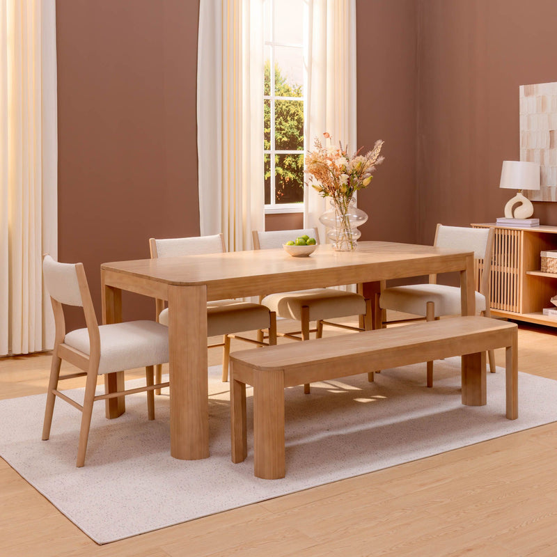 Light wood dining table with bench and upholstered chairs in a modern neutral Scandinavian dining room