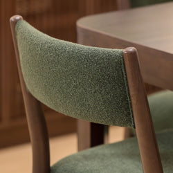 Mid-century modern green upholstered dining chair with wooden frame.