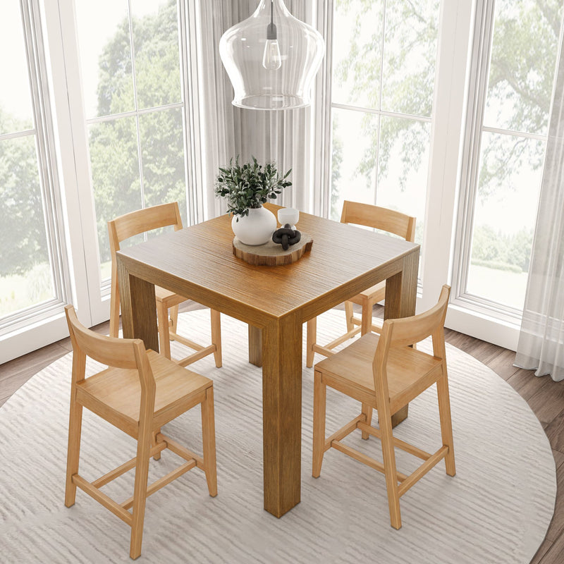 Cozy dining room with a wooden table and four chairs, round rug, and a modern pendant light near large windows.
