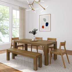 Modern dining room with wooden table, chairs, and bench set on a geometric patterned rug beneath elegant chandelier lighting.