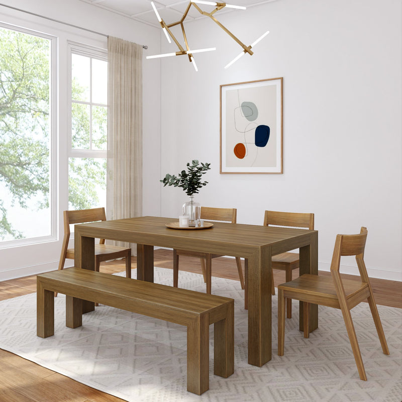 Modern dining room with wooden table, chairs, and bench set on a geometric patterned rug beneath elegant chandelier lighting.