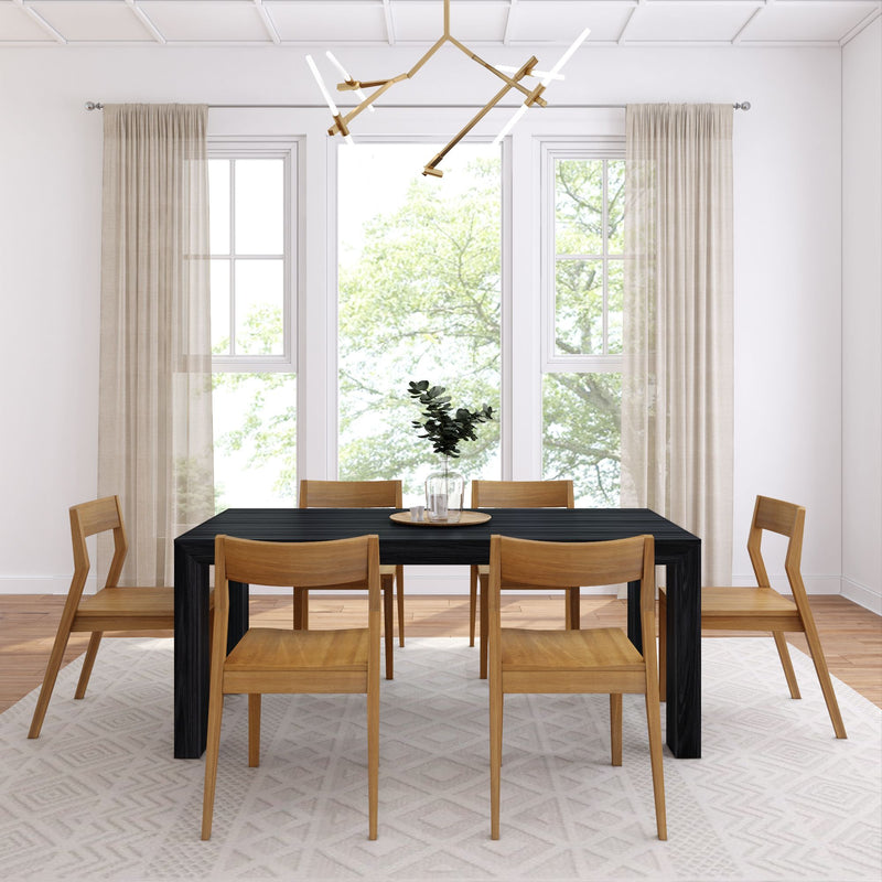 Modern dining room with wooden chairs, a black table, geometric rug, and a contemporary chandelier.