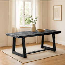 Modern black wooden dining table in a bright minimalist room with decor and natural light.