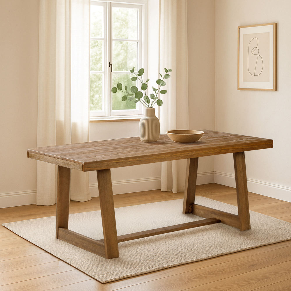 Modern wooden dining table in a bright, minimalist living room with a stylish vase and bowl centerpiece.