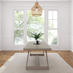 Minimalist Scandinavian dining room with light wood table, rattan pendant light, large windows flooding natural light, greenery centerpiece, hardwood floors and neutral rug