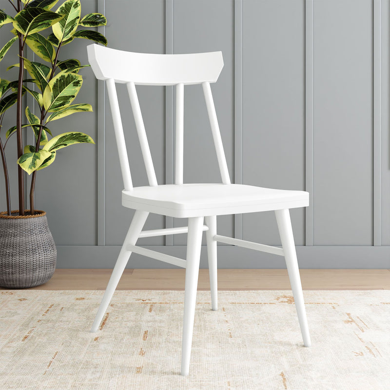 White wooden chair in a minimalistic room setting with a potted plant and beige rug.