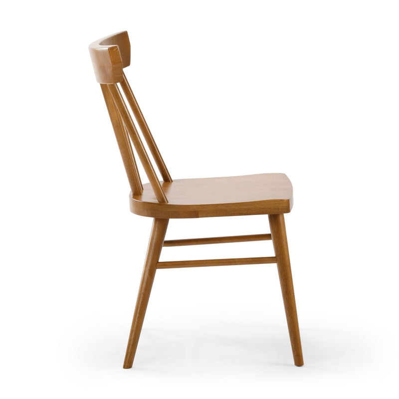 Side view of a mid-century modern solid wood dining chair with spindle back and natural oak finish on a white background