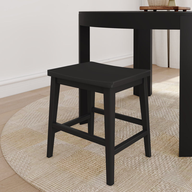 Modern black wooden stool with square seat under black dining table on round woven rug over light hardwood floor