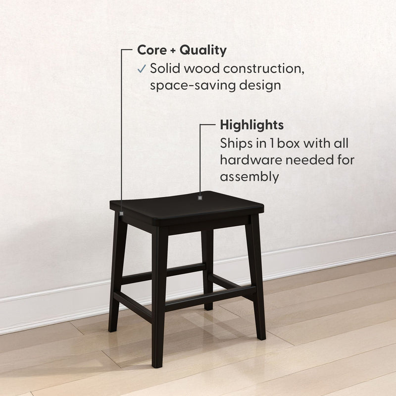 Black solid wood square stool on light hardwood floor against white wall — space-saving kitchen stool with crossbar supports, durable solid wood construction, ships in one box with hardware for easy assembly