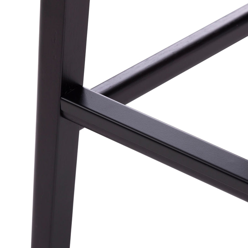 Close-up of black metal furniture leg and crossbar joint — matte black finish modern industrial table or stool frame detail