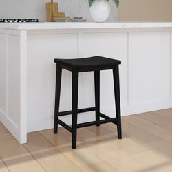 Black wooden bar stool next to a white kitchen counter on light wood flooring in a modern kitchen setting.