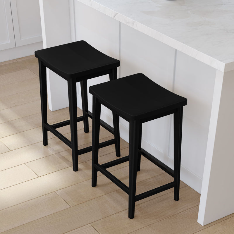 Black wooden bar stools with a modern design beside a white kitchen island on a hardwood floor.
