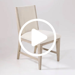 Modern upholstered dining chair with light-washed wood frame and cream fabric seat and back, neutral farmhouse style — product video thumbnail
