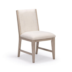 Modern upholstered dining chair with light wood frame and cream fabric upholstery.