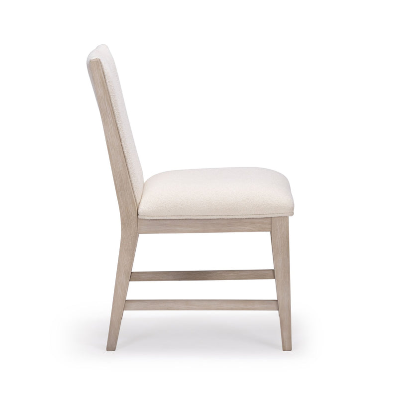 Side view of a modern beige upholstered dining chair with a light wood frame, ideal for contemporary home decor.