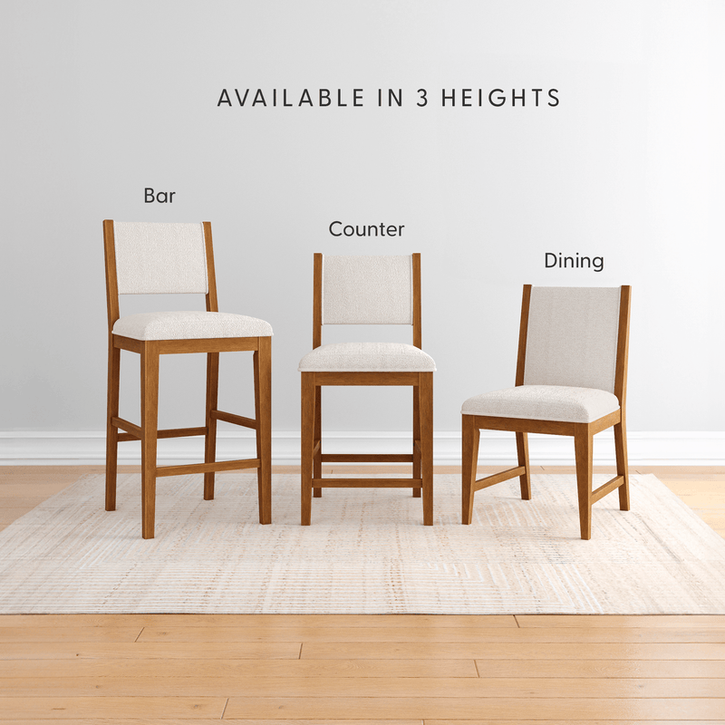 Three wooden chairs with upholstered seats in bar, counter, and dining heights on a light rug.