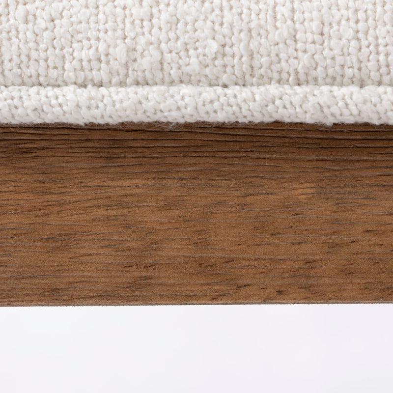 Close-up of textured white fabric on wooden surface for furniture upholstery design.