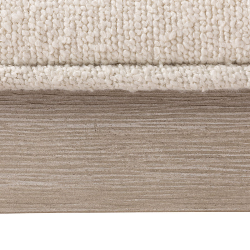 Cream boucle fabric texture with wooden panel background.