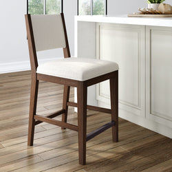 Rustic wooden bar stool with white cushioned seat in a modern kitchen setting.