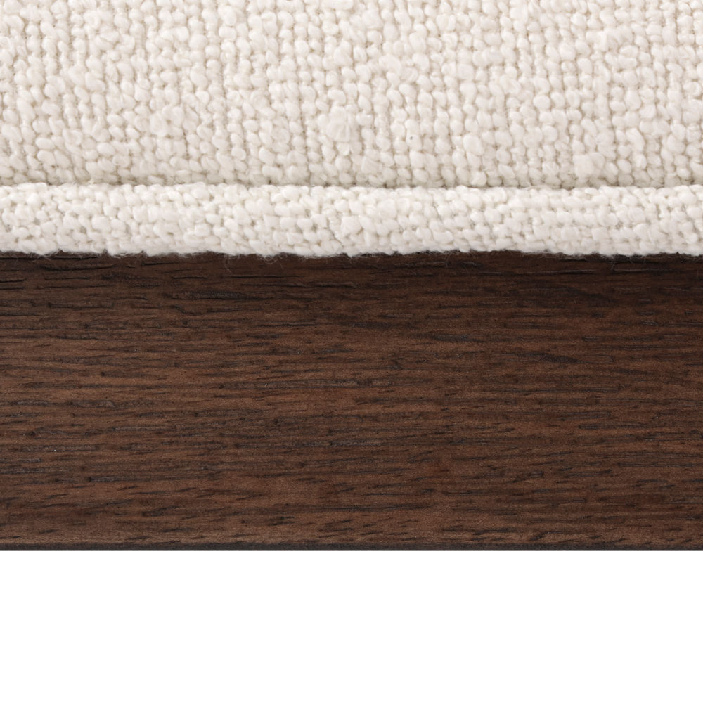 Close-up view of textured fabric above dark wood grain for interior design inspiration.