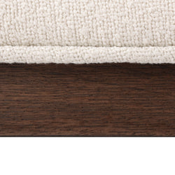 Close-up view of textured fabric above dark wood grain for interior design inspiration.