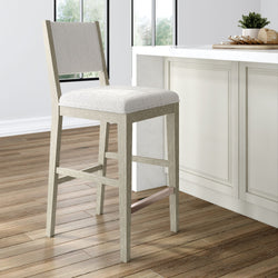 Modern wooden bar stool with cushioned seat in a bright kitchen setting.
