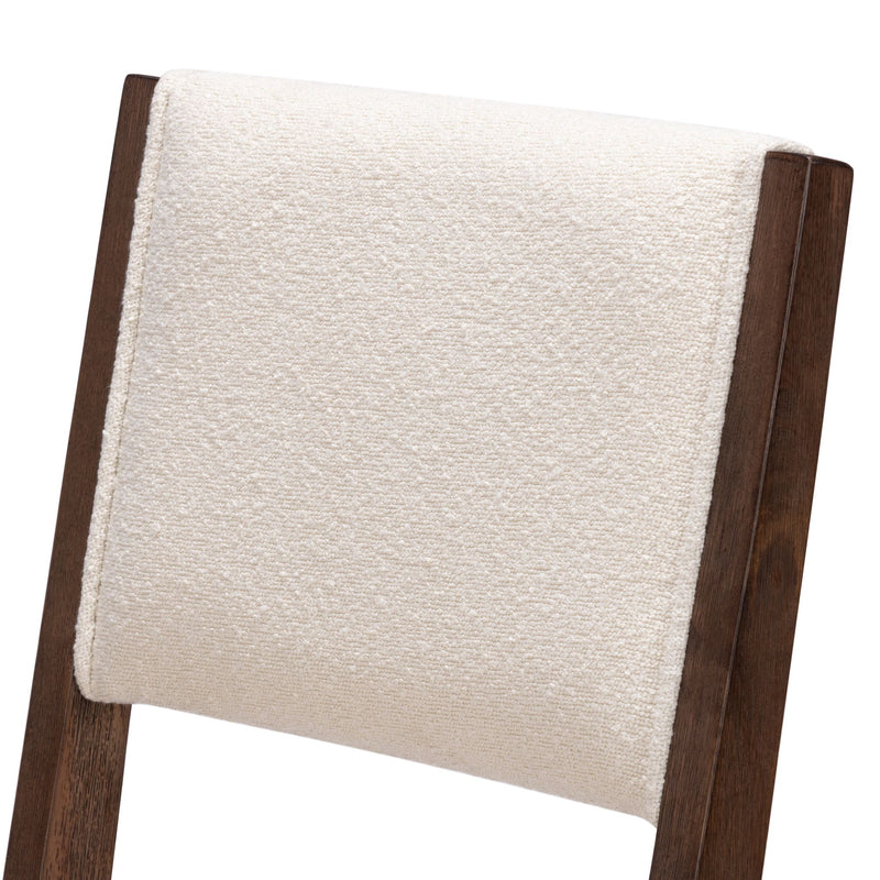 Beige textured fabric on dark wooden chair backrest.