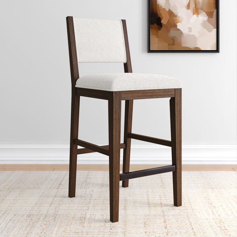 Stylish wooden bar stool with white cushioned seat in modern interior setting.