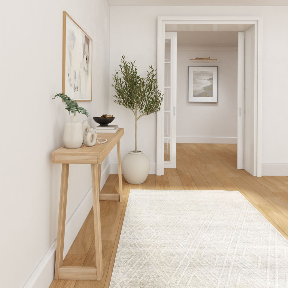 Modern minimalist hallway with wooden floor, potted plant, and a light wood console table.