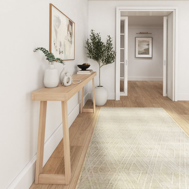 Modern minimalist hallway with wooden console table, decorative vases, and wall art, featuring a neutral rug and indoor plant for stylish home décor.