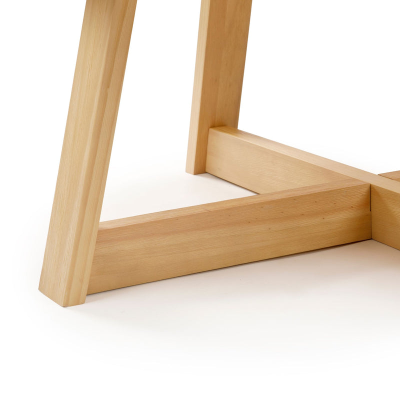 Wooden table leg and support structure on a modern minimalist table design.