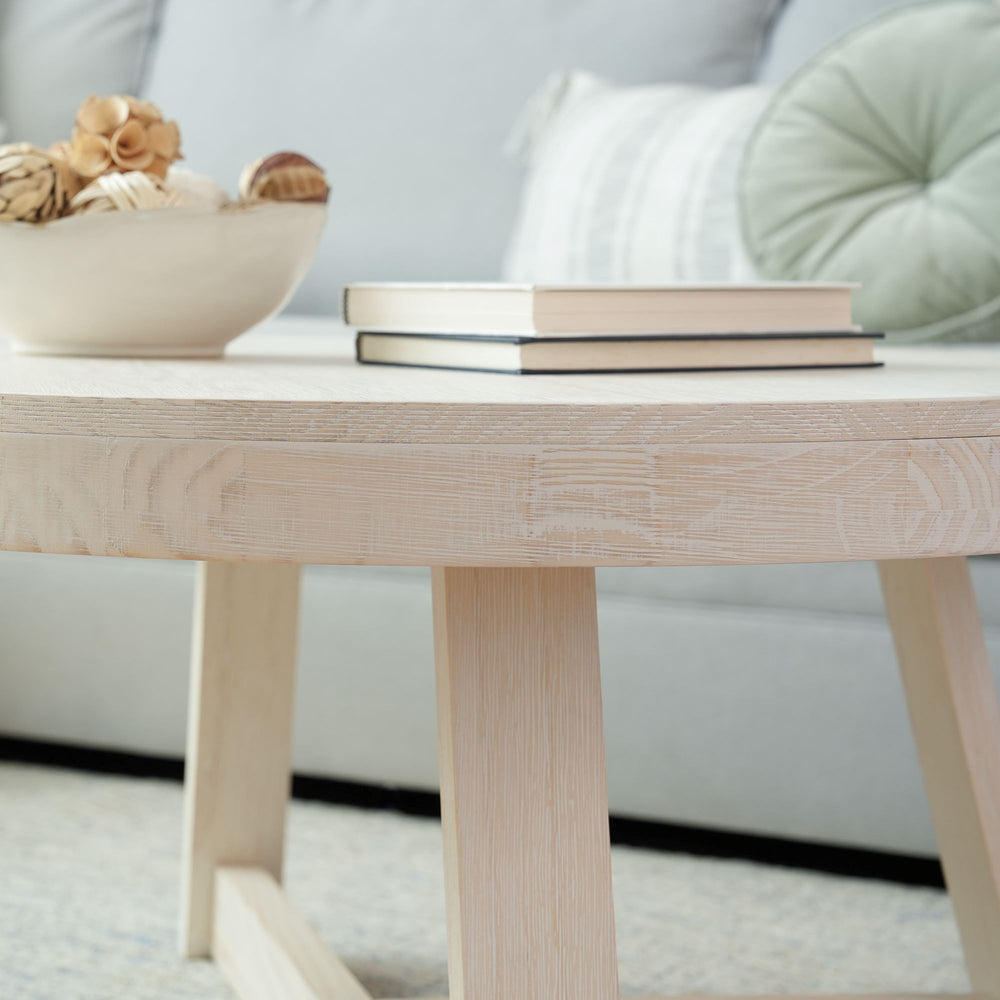 Minimalist living room with a wooden coffee table, books, and decorative bowl.