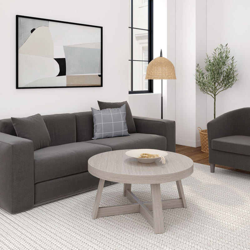 Modern living room interior with dark gray sofa, abstract wall art, and wooden coffee table.