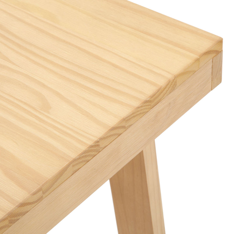 Close-up view of a wooden table corner with natural grain texture.