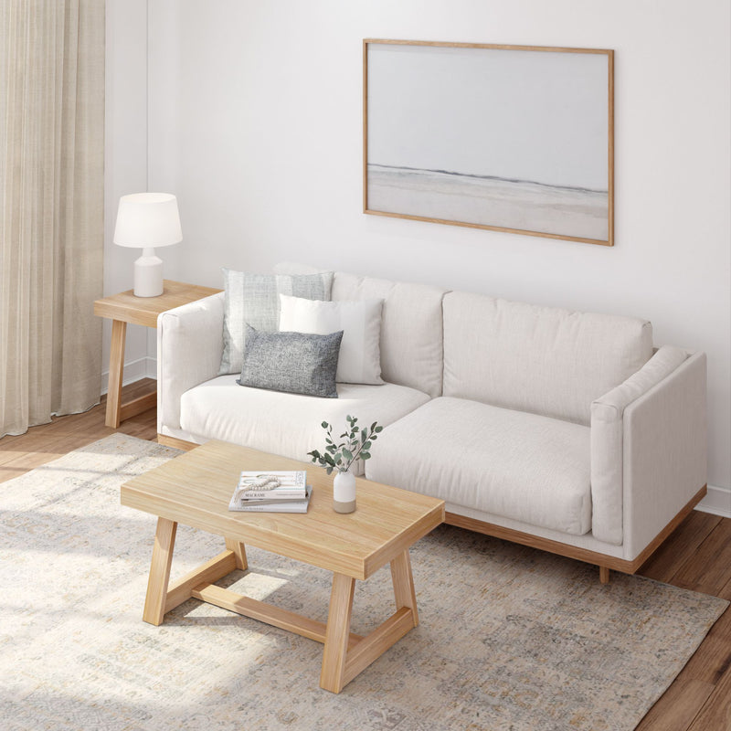Modern living room with a beige sofa, wooden coffee table, and minimalist decor.