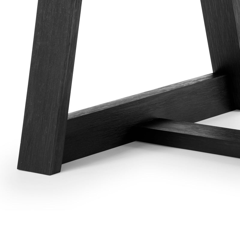 Close-up of modern black wooden table leg showing sleek design and craftsmanship.