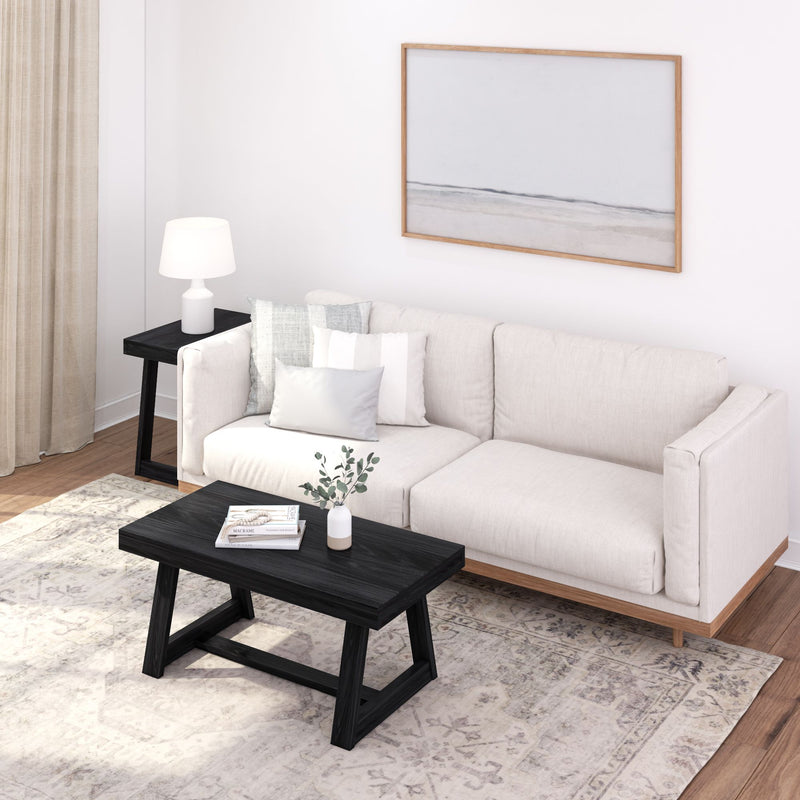 Modern minimalist living room with white sofa, black coffee table, and neutral decor.