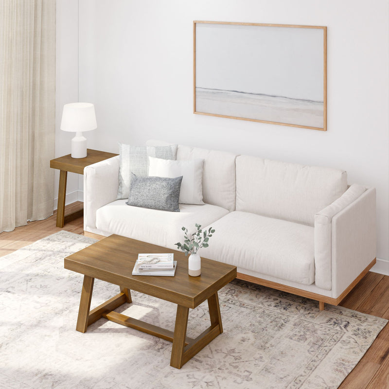 Modern living room with white sofa, wooden coffee table, and minimalist decor elements.