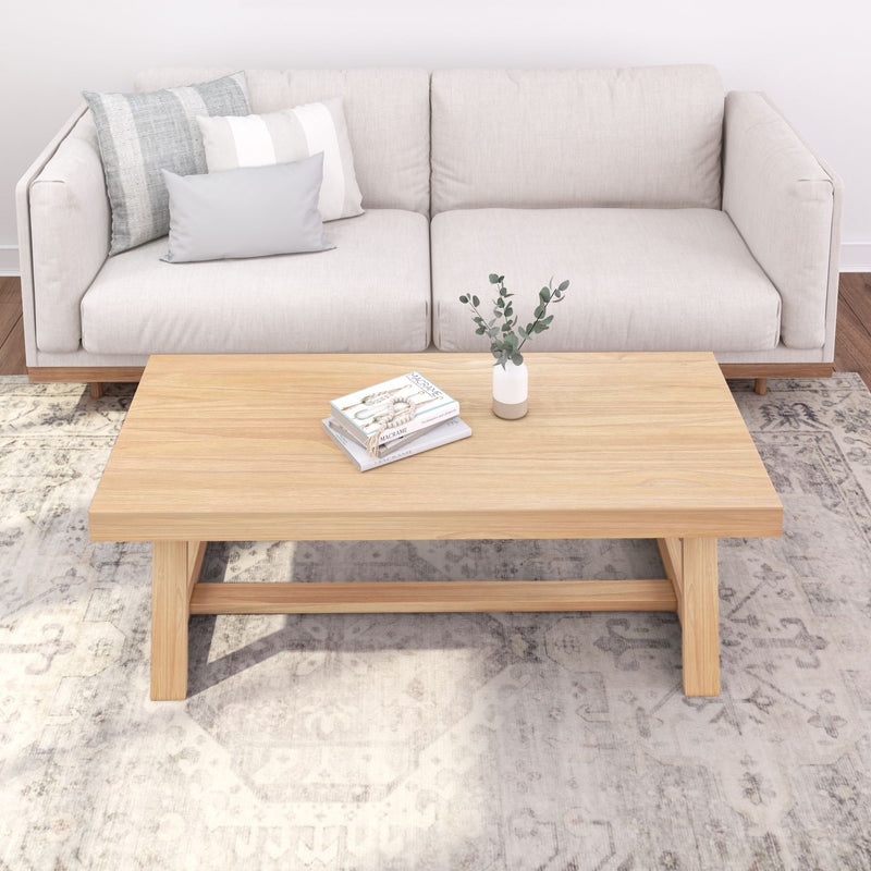 Beige sofa with decorative pillows and a wooden coffee table in a stylish living room.
