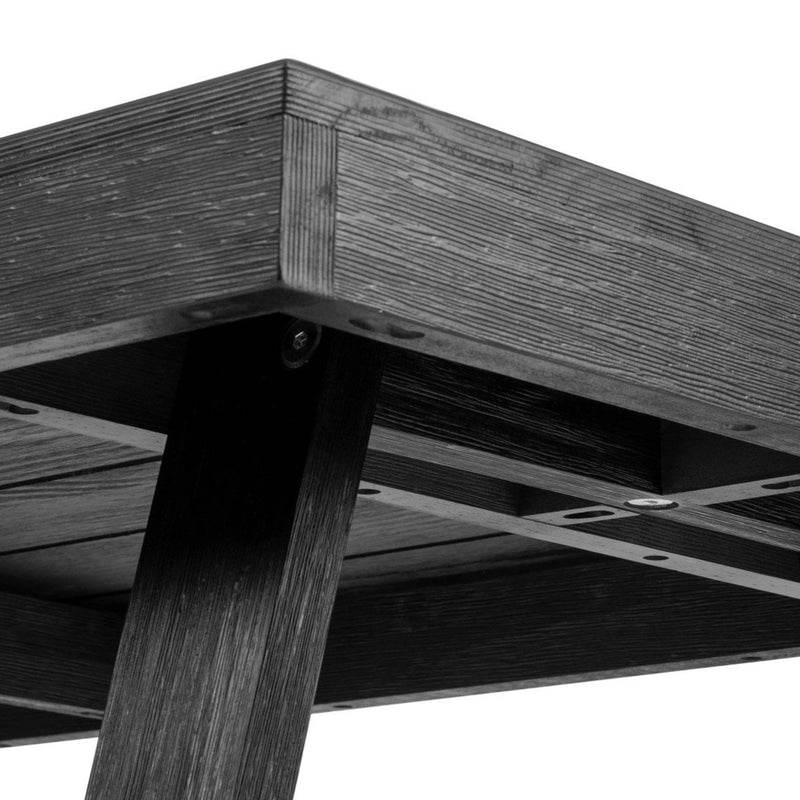 Close-up view of a modern dark wooden table with slanted legs and textured surface.